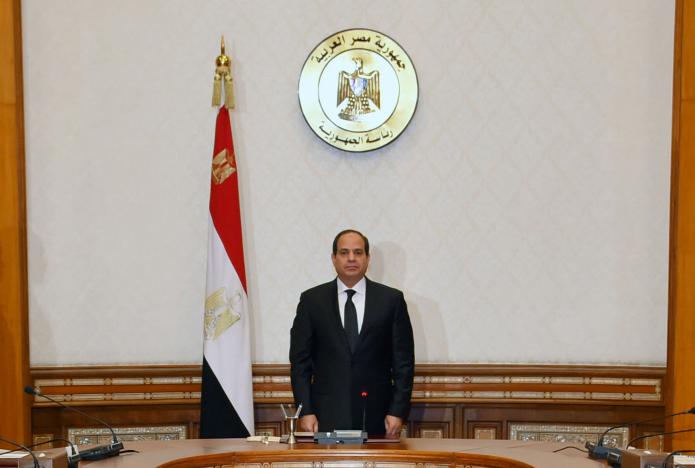 Egyptian President Abdel Fattah al-Sisi stands and holds a moment of silence for those killed