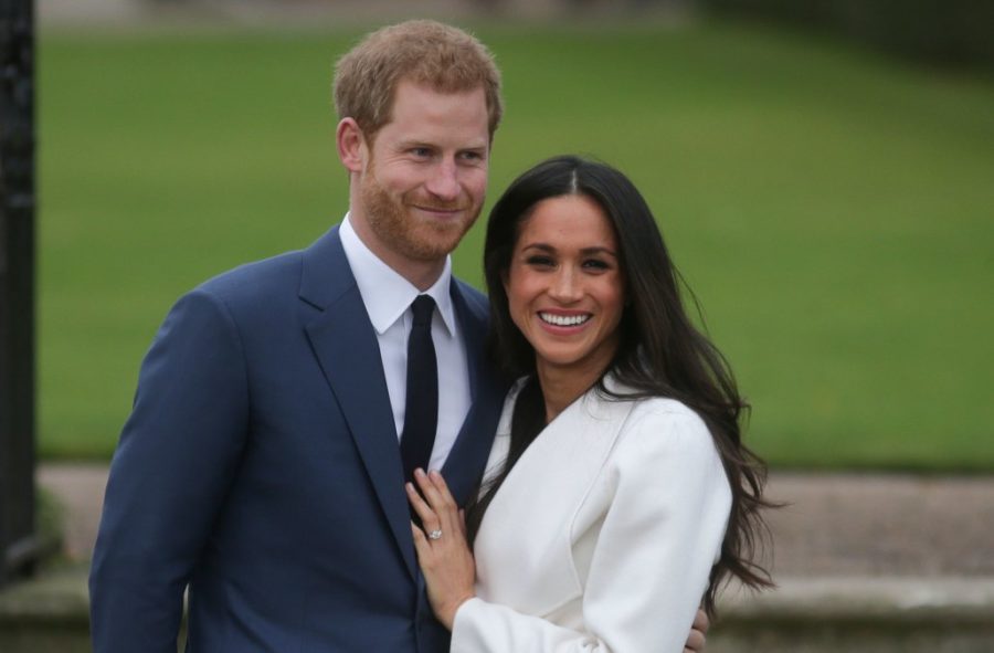 Britain's Prince Harry stands with his fiancée US actress Meghan Markle as she shows off her engagement ring whilst they pose for a photograph in the Sunken Garden at Kensington Palace in west London on November 27, 2017, following the announcement of their engagement.
Britain's Prince Harry will marry his US actress girlfriend Meghan Markle early next year after the couple became engaged earlier this month, Clarence House announced on Monday. / AFP PHOTO / Daniel LEAL-OLIVAS        (Photo credit should read DANIEL LEAL-OLIVAS/AFP/Getty Images)