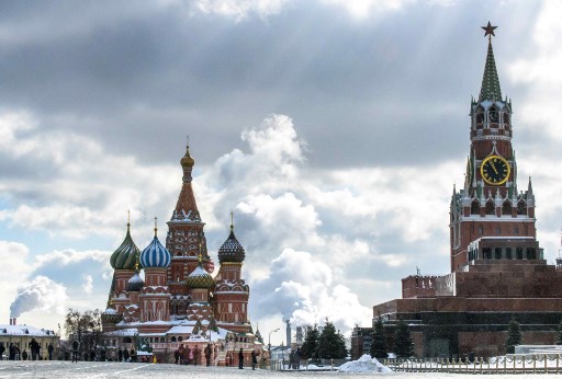 People walk in front of St. Basil's Cathedral and the Kremlin on Red Square in Moscow on March 16, 2018.
Russia will vote for President on March 18. / AFP PHOTO / Mladen ANTONOV