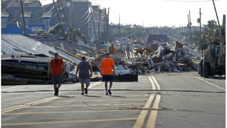 People walk amidst destruction on the main street of Mexico Beach, Fla., in the aftermath of Hurricane Michael inThursday, Oct. 11, 2018. (AP Photo/Gerald Herbert)