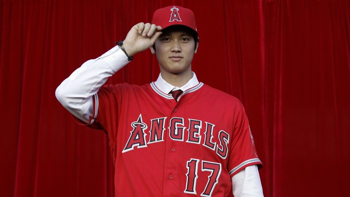 Baseball player Shohei Ohtani, of Japan, poses for photos after a news conference at Angel Stadium, Saturday, Dec. 9, 2017, in Anaheim, Calif. The Japanese star is bringing his arm and bat to the Los Angeles Angels, pairing him with two-time MVP Mike Trout. (AP Photo/Jae C. Hong)