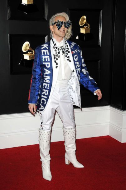 Ricky Rebel is a singer-songwriter. He showed up to the Grammys in a "Keep America Great Again" blazer with some statement glasses. This look was not a fan favorite. The blazer does not coordinate with the rest of his outfit. This kind of look is not classy for the Grammys.