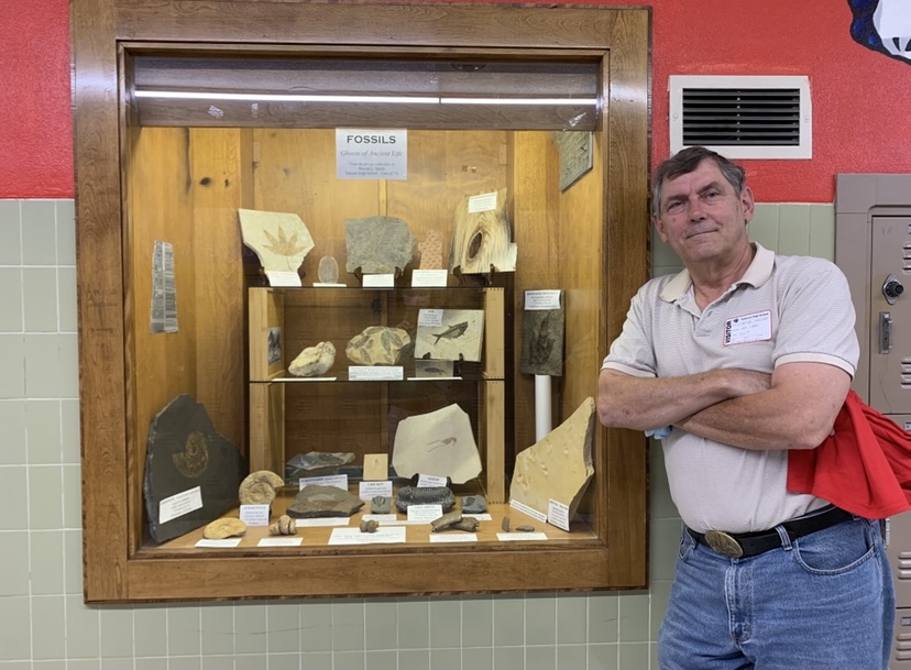 Steve Smith posing with his fossil display at Sahuaro High School.