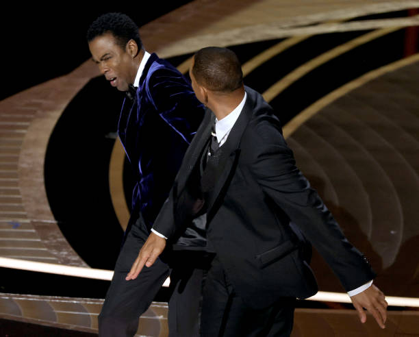 Most commonly known as “The Slap Heard Around the World”, one of the most scandalous celebrity moments of 2022 touched down, or shall we say 'hit,' at the Oscars. Before Will Smith won Best Actor for his role in King Richard, Chris Rock made an admittedly rude joke directed towards Will’s wife, Jada. She has a condition called Alopecia, causing her hair to fall out, so Chris made a quip about G.I. Jane. At first, Will laughed, but after realizing Jada rolled her eyes, he became angry, walked on stage, slapped him, returned to his seat, and said, “Keep my wife’s name out of your f***ing mouth.” Will Smith was then banned from the Oscars for 10 years.  