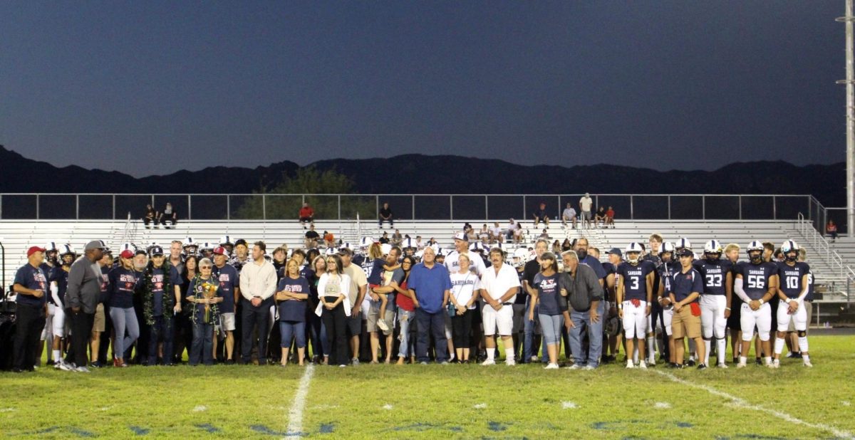 Family of Rick Botkin lines up on the field for a tribute and picture with the team.