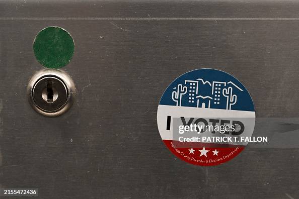 An "I Voted" sticker is displayed on a demonstration ballot lock box at the Maricopa County Tabulation and Election Center (MCTEC) ahead of the 2024 Arizona Primary and General elections in Phoenix, Arizona on June 3, 2024. Maricopa County election workers have repeatedly been the target of harassment and threats since the 2020 US election due to the spread of online misinformation about voter fraud. Officials are preparing for another onslaught of conspiracy theories in the 2024 presidential race by bulking up security and giving public tours at their ballot tabulation facility in downtown Phoenix, Arizona. (Photo by Patrick T. Fallon / AFP) (Photo by PATRICK T. FALLON/AFP via Getty Images)