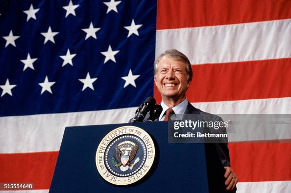 (Original Caption) 3/24/1979-Elk City, Oklahoma: President Jimmy Carter addressing a town meeting. American flag is hung in background.