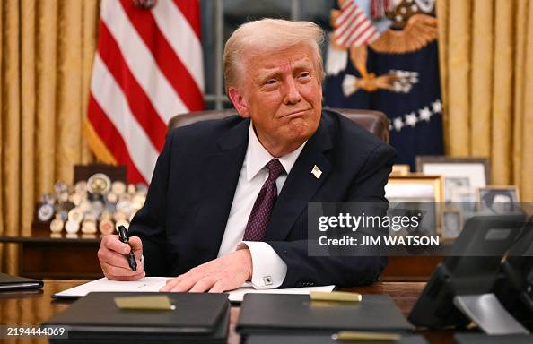 TOPSHOT - US President Donald Trump signs executive orders in the Oval Office of the White House in Washington, DC, on January 20, 2025. (Photo by Jim WATSON / AFP) (Photo by JIM WATSON/AFP via Getty Images)