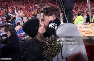 KANSAS CITY, MISSOURI - JANUARY 26: Taylor Swift kisses Travis Kelce #87 of the Kansas City Chiefs after the Chiefs defeated the Buffalo Bills 32-29 to win the AFC Championship Game at GEHA Field at Arrowhead Stadium on January 26, 2025 in Kansas City, Missouri. (Photo by Jamie Squire/Getty Images)