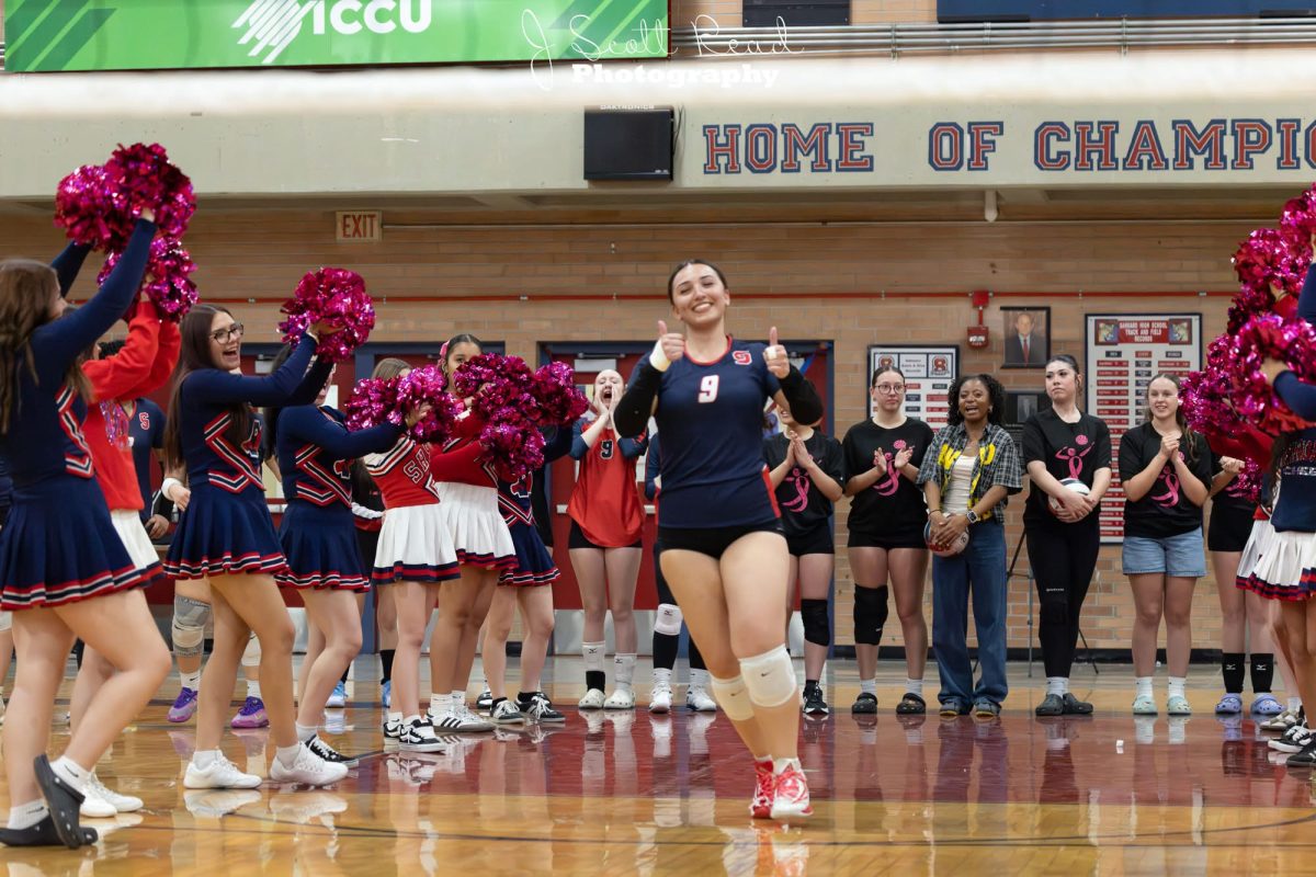 Dela runs through the cheerleader's tunnel
